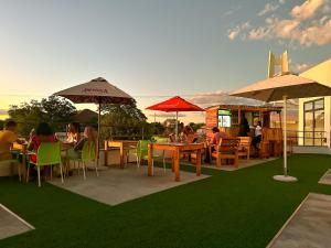 a group of people sitting at tables with umbrellas at TaTe Village in Windhoek