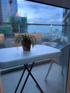 una maceta sentada en una mesa frente a una ventana en Lovely 1bedroom in Parksuites, en Manila