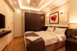 1 dormitorio con 1 cama grande y TV en Lilium Luxury Suites en Estambul