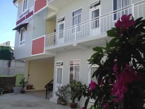 un gran edificio blanco con balcón en Phuong Hong Guesthouse en Dalat