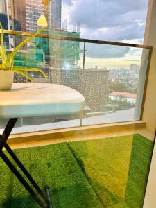 een kamer met een raam met een tafel en een groen tapijt bij Lovely 1bedroom in Parksuites in Manilla