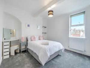 a white bedroom with a bed and a desk at Escape To Ramsgate in Ramsgate