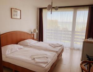 A bed or beds in a room at Riviera Park Hotel Még 24 kép