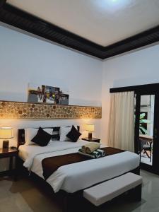 a bedroom with a large bed with two tables and two lamps at Penida Dream Homestay and hostel in Nusa Penida