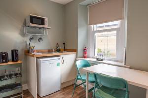 uma cozinha com um frigorífico branco, uma mesa e cadeiras em Union Street Suites em Kelso