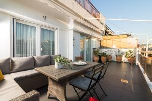 a table and chairs on a balcony with a couch at F & B Collection - 3 Bedroom Penthouse in Thessaloniki