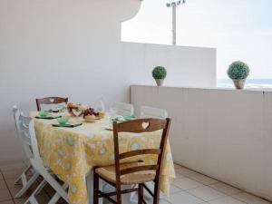 mesa de comedor con mantel amarillo y sillas en Appartement Vieux-Boucau-les-Bains, 2 pièces, 4 personnes - FR-1-379-65, en Vieux-Boucau-les-Bains