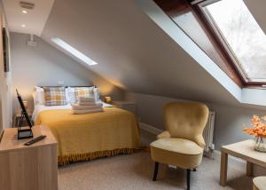 a attic bedroom with a bed and a chair at Union Street Suites in Kelso