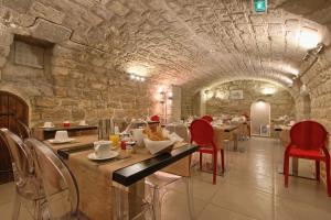 a restaurant with red chairs and a stone wall at Villa Margaux Opéra Montmartre in Paris