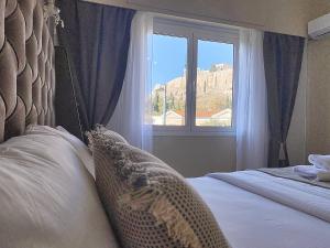 una camera da letto con un letto e una finestra con vista di Check Point - Acropolis View ad Atene