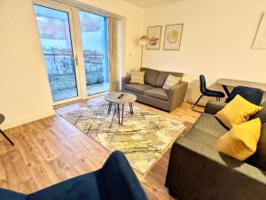 a living room with a couch and a table at Spacious 2 bed ground floor apartment, Free parking, close to Historic dockyard & Gunwharf Quays in Portsmouth