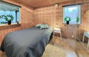 een slaapkamer met een bed in een houten muur bij Stunning Home In sljunga With House A Panoramic View in Åsljunga