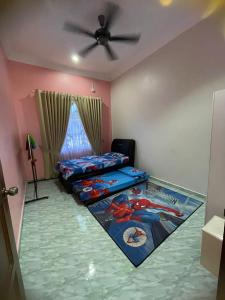a bedroom with two beds and a ceiling fan at DnD Homestay in Kuala Berang