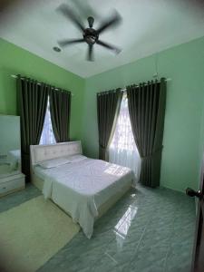 a bedroom with a bed and a ceiling fan at DnD Homestay in Kuala Berang