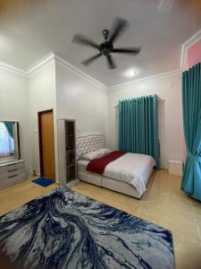 um quarto com uma cama e uma ventoinha de tecto em DnD Homestay em Kuala Berang