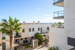an apartment building with a palm tree in front of it at 3082 Res LOMAS DE CAMPOAMOR in Orihuela Costa