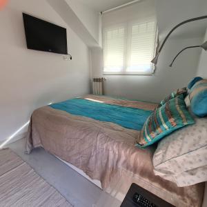 Schlafzimmer mit einem Bett und einem Flachbild-TV in der Unterkunft Ático Somo Beach in Somo
