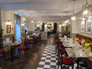 uma sala de jantar com mesas e cadeiras num restaurante em Burnham Beeches Hotel em Slough