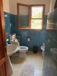 een badkamer met een wastafel, een toilet en een raam bij Villa Carmen di Torre delle Stelle in Torre delle Stelle