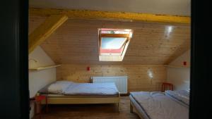 een slaapkamer op zolder met 2 bedden en een raam bij Chata pod hradem in Sloup
