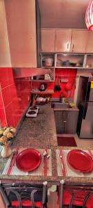 a kitchen with red walls and red plates on a counter at Birch Tower Private Studio with Manila City Metro View in Manila