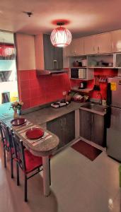 a kitchen with a table and a red wall at Birch Tower Private Studio with Manila City Metro View in Manila