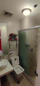 a bathroom with a toilet and a sink and a shower at Birch Tower Private Studio with Manila City Metro View in Manila