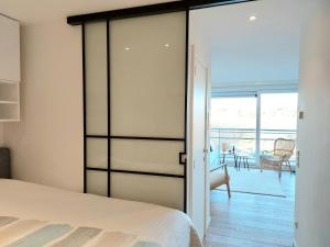 a bedroom with a sliding glass door leading to a patio at Studio 3 Bredene met strandcabine in Bredene