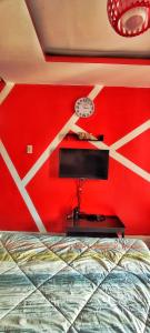 a bedroom with a red wall with a bed and a clock at Birch Tower Private Studio with Manila City Metro View in Manila