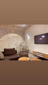 een woonkamer met een bank en een flatscreen-tv bij Welcome Hom in the heart of RABAT in Rabat