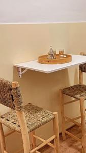 um balcão com duas cadeiras e uma mesa com uma prateleira em Welcome Hom in the heart of RABAT em Rabat