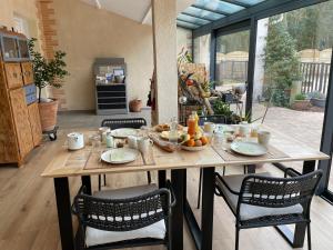 - une table en bois avec des chaises et de la nourriture dans l'établissement Les Hauts de Beillard, à Merville