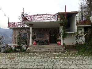 a house with a balcony on top of it at Eagle Nest Cottage Muzaffarabad by LMC in Muzaffarabad