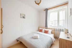 sypialnia z białym łóżkiem i oknem w obiekcie Plac Wilsona Euphony Apartment w Warszawie