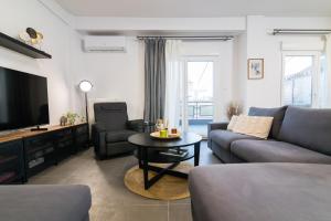 a living room with a couch and a table at F & B Collection - 3 Bedroom Penthouse in Thessaloniki