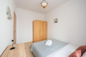 sypialnia z łóżkiem i drewnianą szafką w obiekcie Plac Wilsona Euphony Apartment w Warszawie
