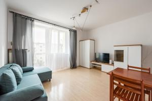salon z kanapą i stołem w obiekcie Plac Wilsona Euphony Apartment w Warszawie