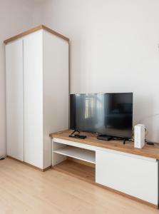 salon z telewizorem na stole w obiekcie Plac Wilsona Euphony Apartment w Warszawie +9 zdjęć
