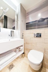 Un baño blanco con inodoro y lavabo. en Original Sokos Hotel Lakeus Seinäjoki, en Seinäjoki 29 fotos más