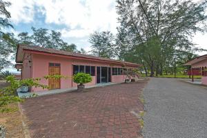 un edificio rosa con un camino de ladrillo delante de él en OYO 90744 Bari Indah Beach Resort, en Kuala Terengganu