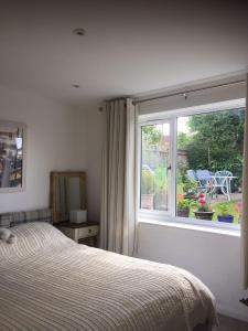 a bedroom with a bed and a large window at The Guest Suite, Buttsfield Lane. in East Hoathly