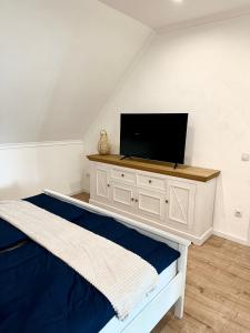 un televisor sentado en la parte superior de una cómoda blanca en Stadthaus Apartment Bachperle, en Mayen