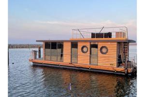 巴特Hausboot Fjord HAVEN mit Biosauna in Barth的一艘大型木船坐在水中