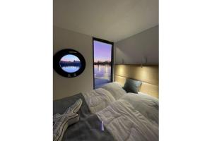 a bedroom with a large bed and a mirror at Hausboot Fjord HAVEN mit Biosauna in Barth in Barth