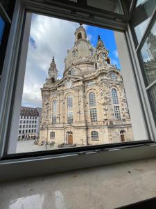 Blick auf ein großes Gebäude durch ein Fenster in der Unterkunft Gemütliches Apartment mit Blick zur Frauenkirche in Dresden