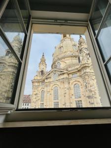 Blick auf ein Gebäude durch ein Fenster in der Unterkunft Gemütliches Apartment mit Blick zur Frauenkirche in Dresden