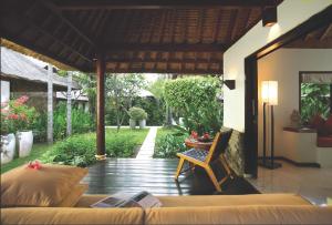 a porch of a house with a couch and a table at Qunci Villas Resort in Senggigi