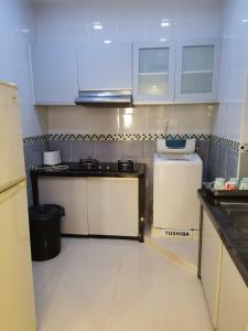 una pequeña cocina con armarios blancos y fregadero en Seri Sayang 2 Apartment suite with 2bedroom, en Ayer Itam
