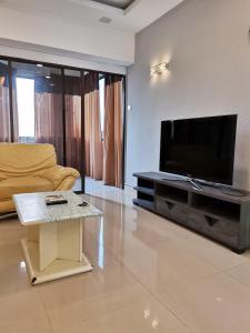 sala de estar con TV, sofá y mesa en Seri Sayang 2 Apartment suite with 2bedroom, en Ayer Itam