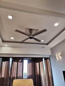 ventilador de techo en la sala de estar con ventana en Seri Sayang 2 Apartment suite with 2bedroom, en Ayer Itam